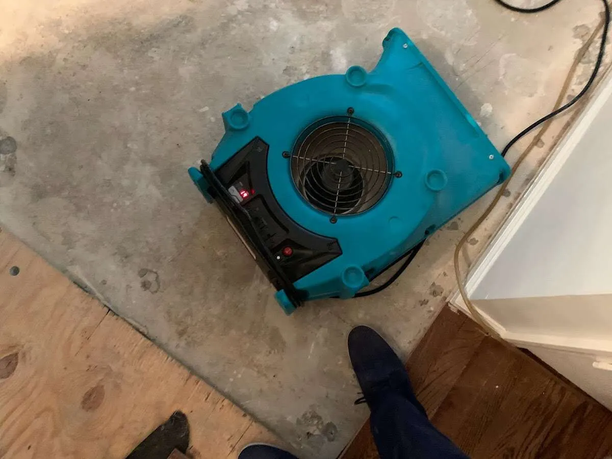 Air mover drying subfloor during Commercial Water Damage Restoration in Vinton